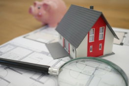 white and red wooden house beside grey framed magnifying glass